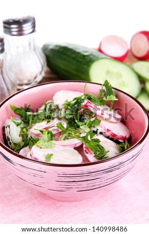 Vitamin vegetable salad in bowl with ingredients isolated on white