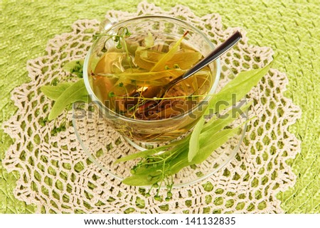 Glass cup of tea with linden on napkin close-up