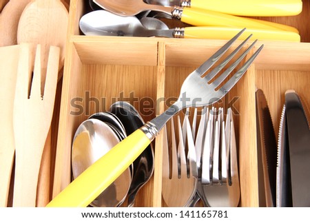 Checked cutlery in wooden cutlery box close up