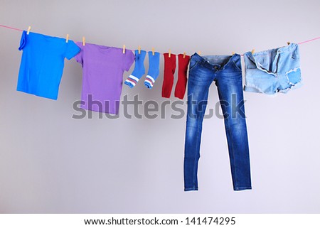 Laundry line with clothes on wall background