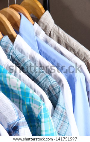 Men\'s shirts on hangers on gray background