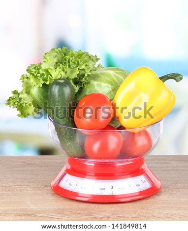 Fresh vegetables in scales on table in kitchen