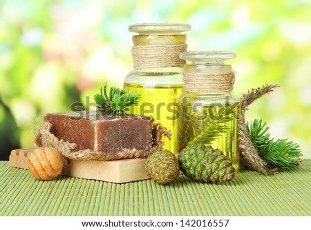 Hand-made soap and bottles of fir tree oil on bamboo mat