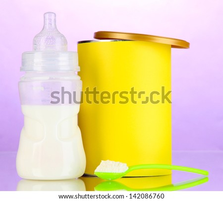Bottle with milk and food for babies on purple background