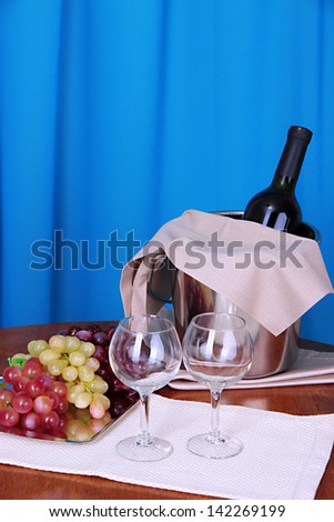 Wine and glasses on round table on cloth background