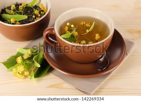 Cup of tea with linden on napkin   wooden table