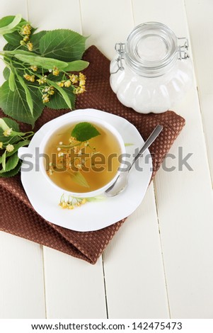 Cup of tea with linden on napkin on   wooden table