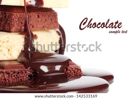 Slices of milk and white chocolate bar poured chocolate close-up