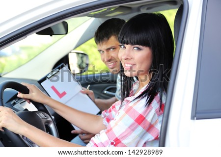 Beautiful young woman  taking driving lesson