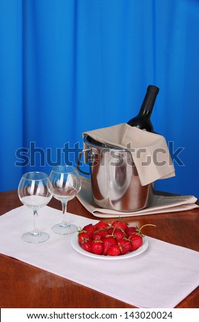 Wine and glasses on round table on cloth background