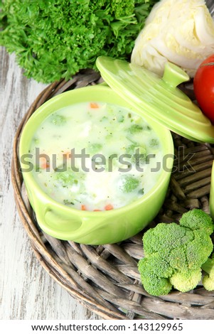 Cabbage soup in plates on braided tray on napkin on wooden table
