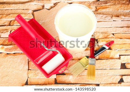 Set for painting: paint pot, brushes, paint-roller on stone background