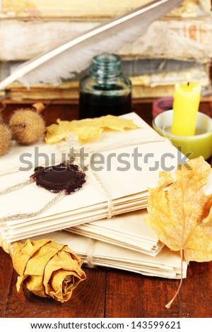 Stacks of old letters with dried autumn leafs on wooden table