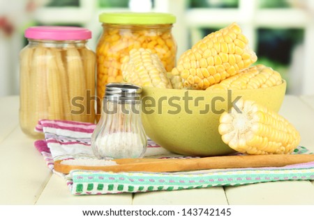 Canned corn, boiled corn in bowl, on wooden  table, on bright background