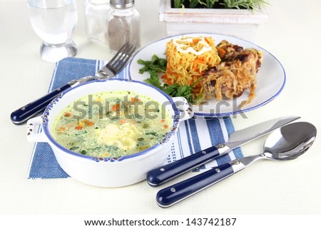 Soup and rice with meat in plates on napkin on table