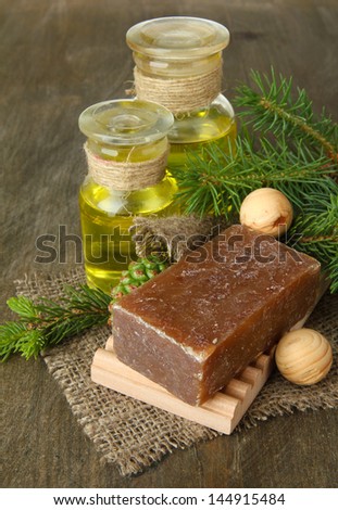 Hand-made soap and bottles of fir tree oil on wooden background