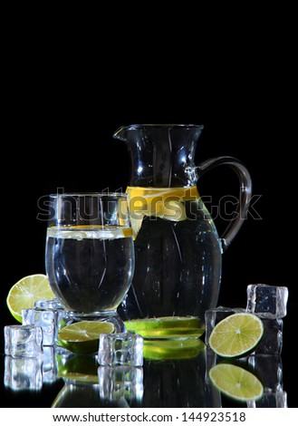 Glass pitcher of water and glass isolated on black