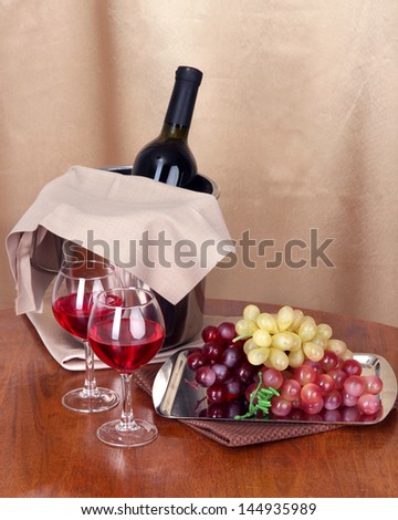 Vine and glasses on round table on cloth background