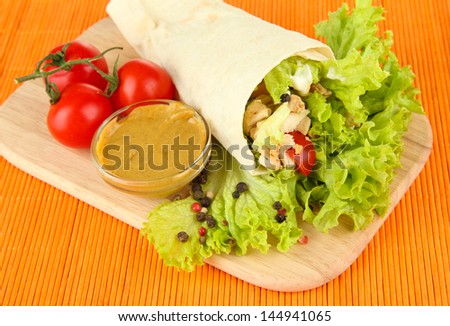 Kebab - grilled meat and vegetables, on wooden board, on bamboo mat background