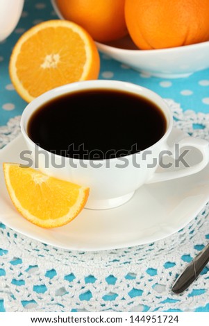 Beautiful white dinner service with oranges on blue tablecloth close-up