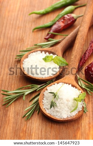 salt in spoons with herbs and vegetables isolated on white