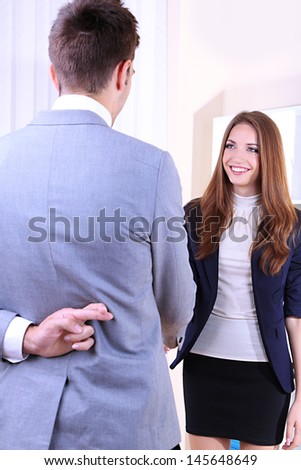 Business colleagues shaking hands and one of them crossing fingers behind his back