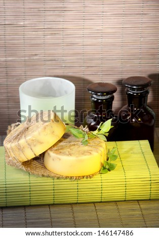 Hand made soap and ingredients for soap making on bamboo mat background