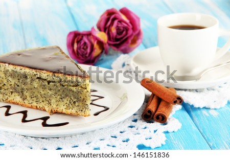 Delicious poppy seed cake with cup of coffee on table close-up