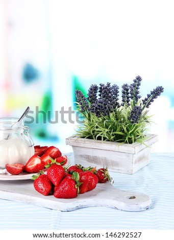 Strawberries on cutting board on table on room background