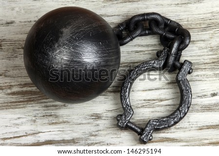 Ball and chain on wooden background