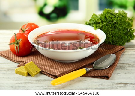 Bowl of soup with bouillon cubes on wooden table