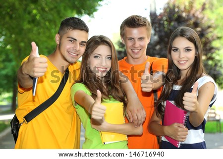 Happy group of young students standing in park