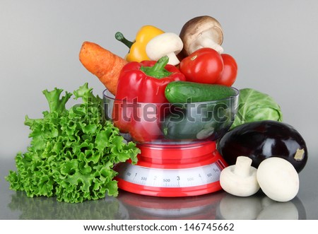 Fresh vegetables in scales on gray background