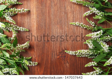Fresh mint flowers on wooden background