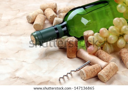Bottle of wine, grapes and corks on old paper background