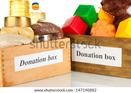 Donation box with food and children\'s toys on white background close-up