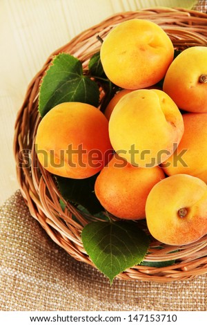 Apricots on wicker coasters on bagging on wooden table