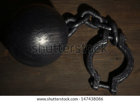 Ball and chain on wooden background