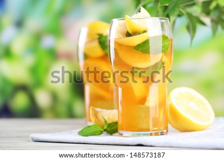 Iced Tea With Lemon And Mint On Wooden Table, Outdoors
