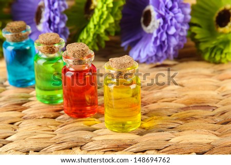 Bottles with colored liquids on  wicker wooden background