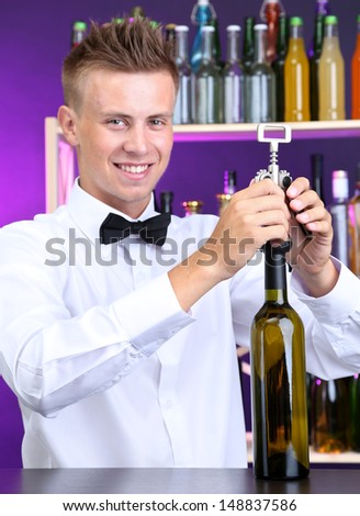 Bartender opens bottle of wine