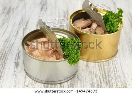 Open tin cans, on wooden background