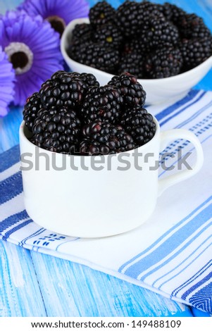 Sweet blackberries in cup on table close-up