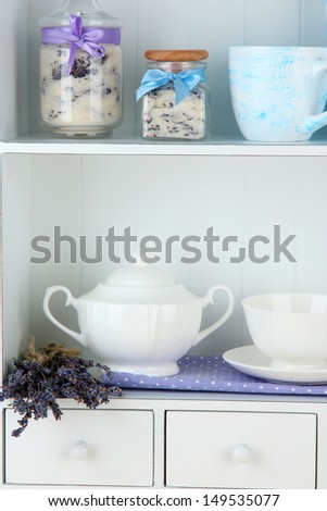 Still life with jar of lavender sugar, cup and fresh lavender flowers on shelves