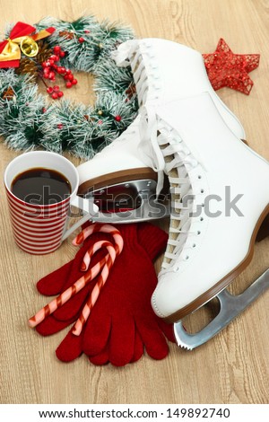 Figure skates with cup of coffee on table close-up