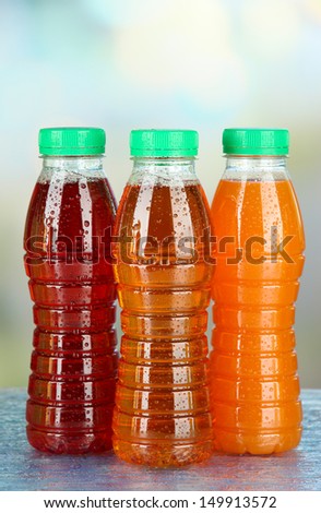 Assortment of bottles with tasty fruit juices on bright background