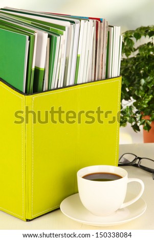 Magazines and folders in green box,on office interior background