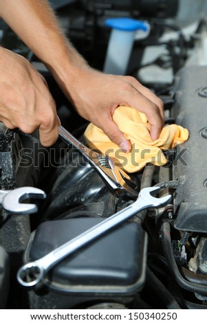 Hand with wrench. Auto mechanic in car repair