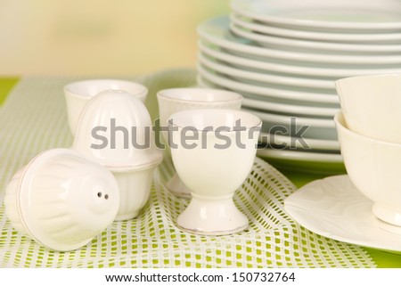Lots beautiful dishes on wooden shelf on bright background