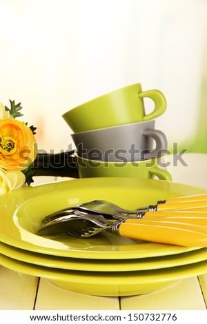 Lots beautiful dishes on wooden table on bright background